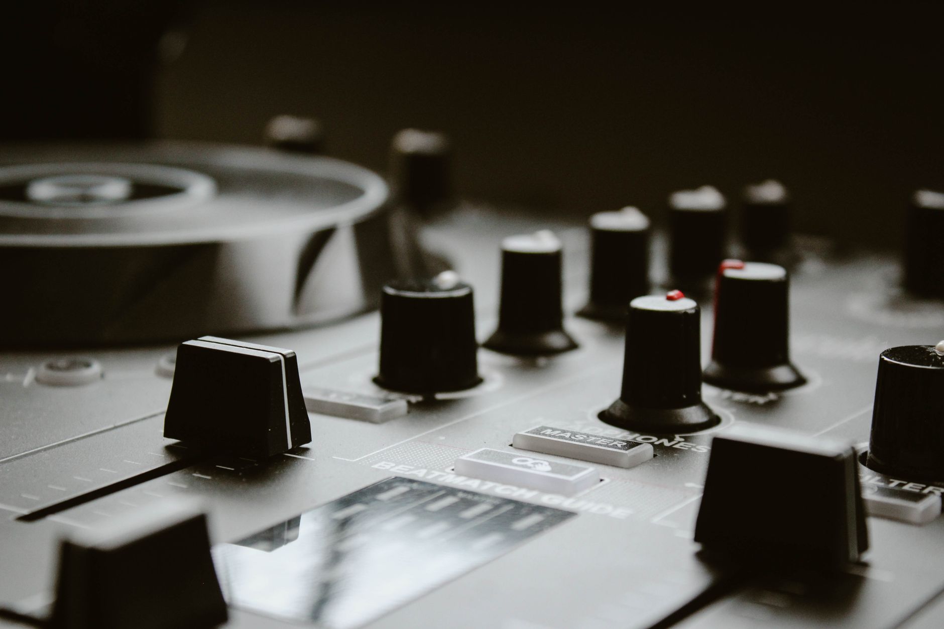 Detailed close-up of a DJ mixing console featuring knobs and sliders, ideal for music production themes.