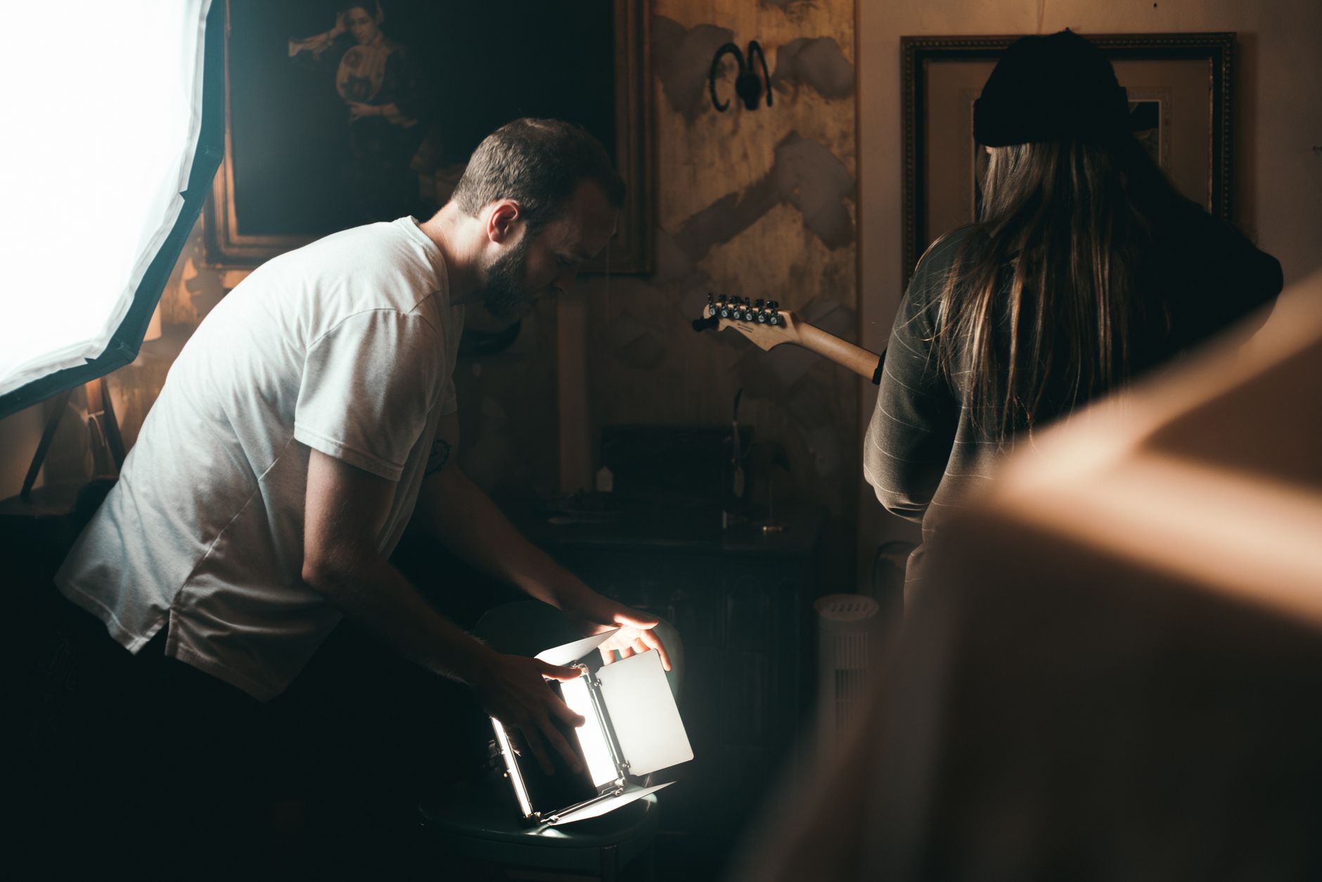A cinematic moment with a filmmaker adjusting lighting on set, creating the perfect atmosphere.